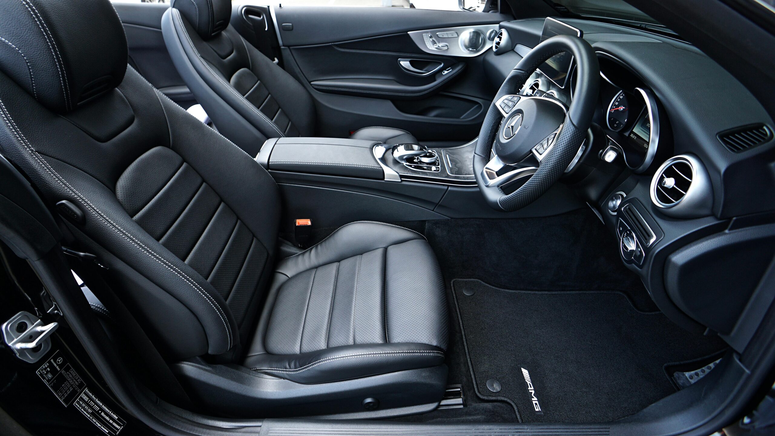 Sleek black Mercedes-Benz interior featuring leather seats and modern dashboard design.